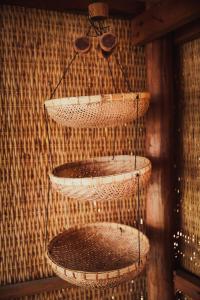 a group of baskets hanging on a wall at Eden Eco Village in Kampot