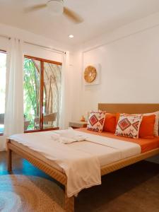 a large bed in a room with a clock on the wall at Tropical Temple Siargao Resort in General Luna