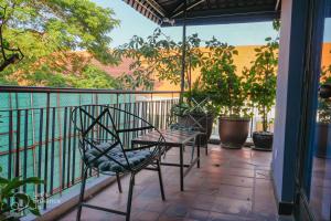 a patio with a table and chairs on a balcony at Bat Chum Villa in Phnom Penh