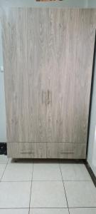 a wooden garage door in a room with a tile floor at Spacious one bedroom Bangalow -8E3 in Kampala