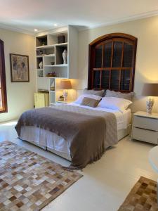 a bedroom with a large bed with a large window at Restau de Marambaia in Barra de Guaratiba