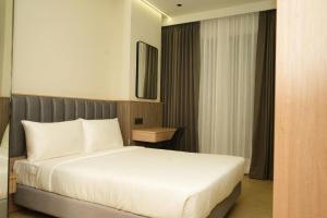 a bedroom with a white bed in a hotel room at APL Residency by Darling in Vishāram