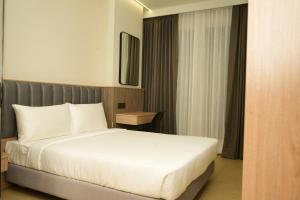 a bedroom with a white bed and a table at APL Residency by Darling in Vishāram
