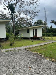 a small white house with a gravel driveway at Bungalows Chachagüita in Fortuna