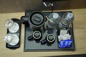 a tray with cups and water bottles on a table at APL Residency by Darling in Vishāram