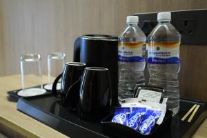 a black tray with two bottles of water and glasses at APL Residency by Darling in Vishāram