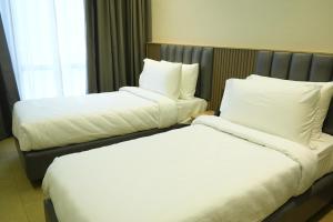 two beds sitting next to each other in a hotel room at APL Residency by Darling in Vishāram +17 photos