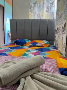 a bed with a colorful comforter on top of it at GuestHouse Detours CR in Fortuna