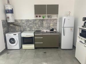 a kitchen with a refrigerator and a washer and dryer at El Remanso de Paracao in Paraná