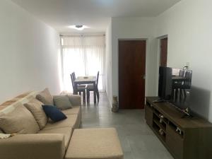 a living room with a couch and a television at El Remanso de Paracao in Paraná