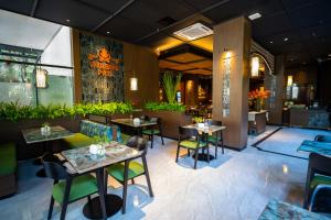a restaurant with tables and chairs in a room at Deka Hotel Surabaya HR Muhammad in Surabaya