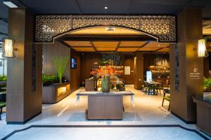 a lobby of a hotel with a table with flowers on it at Deka Hotel Surabaya HR Muhammad in Surabaya