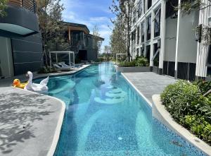 a swimming pool with two swans in the middle of a building at Bellevue Lagoon Phuket in Laguna Phuket