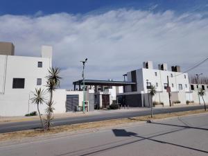 a building on a street with palm trees in front of it at Amplia casa equipada para familia, pareja o individual in Tizayuca