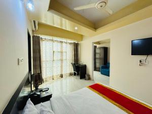a bedroom with a bed and a flat screen tv at Hotel Progati Inn Ltd. in Dhaka
