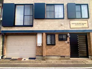 a building with two garage doors on a street at AJITO Hostel 別館 in Shingū