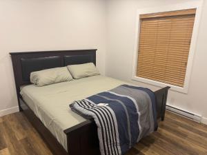 a bedroom with a bed and a window with a blanket on it at Next rental in Vernon