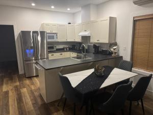 a kitchen with a table and a stainless steel refrigerator at Next rental in Vernon