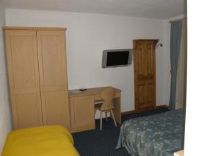 una camera d'albergo con letto e scrivania con computer di Villa Ilaria a Caderzone