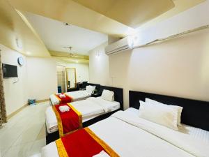 a room with four beds and a tv in it at Hotel Progati Inn Ltd. in Dhaka +65 photos
