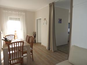kuchnia i jadalnia ze stołem i krzesłami w obiekcie Warmbad Apartments w Villach