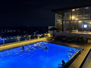 a swimming pool with people in it at night at Azure Luxury Apartment Luxury Stay Near Airport Negombo in Negombo