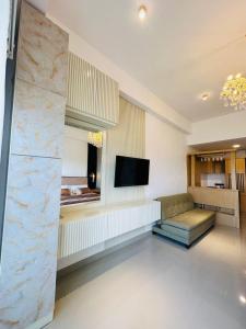 a living room with a couch and a flat screen tv at Azure Luxury Apartment Luxury Stay Near Airport Negombo in Negombo