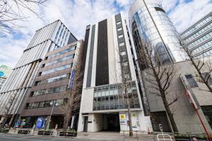 a building with two tall buildings next to a street at KOKO HOTEL Hakata Shinkansenguchi in Fukuoka