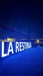 a large sign that reads la revisiting at night at VV Abrante in La Restinga