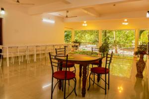 a dining room with a table and chairs in a room at Jotham Gardens in Alleppey