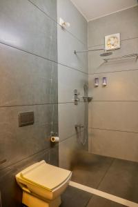 a bathroom with a shower with a yellow toilet at Jotham Gardens in Alleppey +65 photos