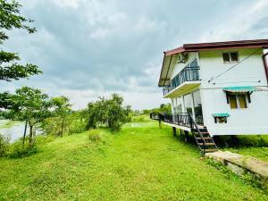 a white building with a staircase next to a river at LEOPARD One Villa in Gotamegama