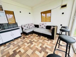 a living room with a couch and two stools at LEOPARD One Villa in Gotamegama