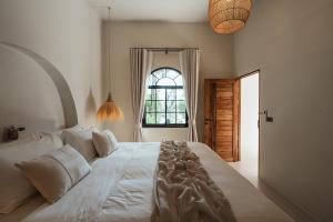 a bedroom with a large white bed with a window at Botanica Villas Koh Chang by Indie Beach in Ban Khlong Kloi