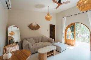 a living room with a couch and a table at Botanica Villas Koh Chang by Indie Beach in Ban Khlong Kloi