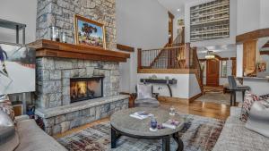 a living room with a large stone fireplace at Bergrose Lodge in Vail