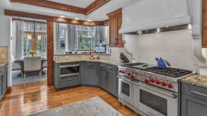 a kitchen with gray cabinets and a stove top oven at Bergrose Lodge in Vail +31 photos