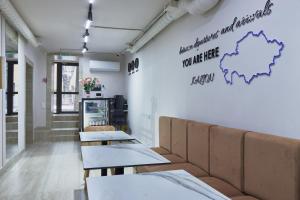 a restaurant with tables and a couch in a room at Kalion Capsule and Boutique Hotel in Almaty