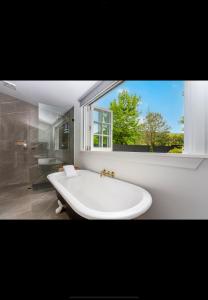 a white bath tub in a bathroom with a window at The old shearers quarters in Glentunnel