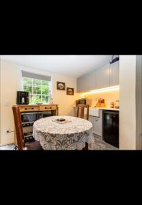 a small kitchen with a table with a table cloth on it at The old shearers quarters in Glentunnel