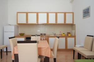 a kitchen with a table and chairs and a kitchen with a kitchen at Apartments Novalja in Novalja +33 photos