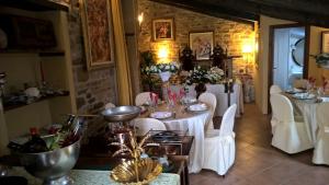 a dining room with white tables and white chairs at Il Paradiso del Re in Arcevia
