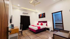 a bedroom with a bed with red pillows at Sun Stayz Inn T - Nagar Chennai in Chennai