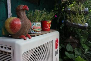 a statue of a chicken sitting on top of a radiator at Noom Guesthouse in Lop Buri