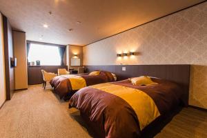 
a hotel room with two beds and two lamps at Hotel Kanronomori in Niseko
