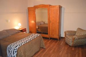 1 dormitorio con cama, espejo y silla en Hotel Mallorca en Mendoza