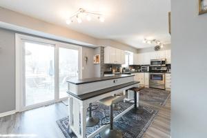 a kitchen with white cabinets and a large window at Heart & HomeStay in Ankeny