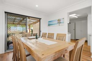 a dining room with a wooden table and chairs at The Nelson Bay Getaway in Nelson Bay +25 photos