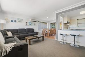 a living room with a couch and a table at The Nelson Bay Getaway in Nelson Bay