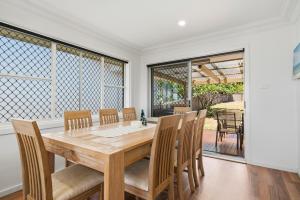 a dining room with a wooden table and chairs at The Nelson Bay Getaway in Nelson Bay